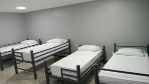 a group of four beds in a room at Aiezza Hotel in Barcarena