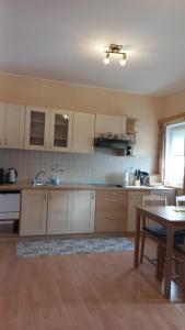 a large kitchen with white cabinets and a table at Apartment Rozika in Slovenj Gradec