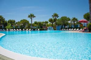 a large blue swimming pool with chairs and a fountain at Appartamenti Bellavista Club Tropea in Tropea +4 photos