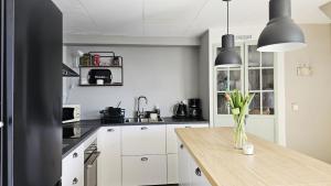 a kitchen with white cabinets and a wooden table at Cozy seaside cottage SE09169 in Myggenäs