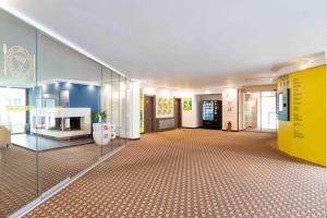 a large room with a hallway with a yellow wall at SLEEEP Hotel Vösendorf in Vösendorf