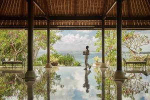 a man standing in the middle of a pool in a villa at Four Seasons Resort Bali at Jimbaran Bay in Jimbaran