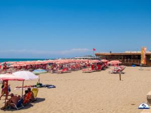 a beach with many umbrellas and people on the sand at La Mozza 739 in Torre San Giovanni Ugento