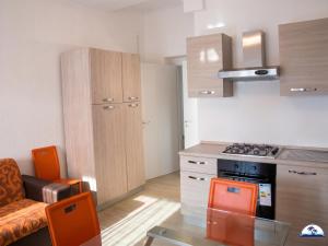 a small kitchen with a stove top oven next to a couch at La Mozza 739 in Torre San Giovanni Ugento