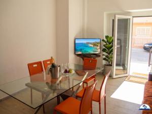 a dining room with a glass table and orange chairs at La Mozza 739 in Torre San Giovanni Ugento
