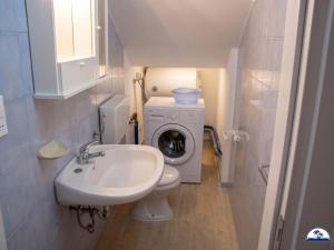 a small bathroom with a washing machine and a sink at La Mozza 739 in Torre San Giovanni Ugento +3 photos
