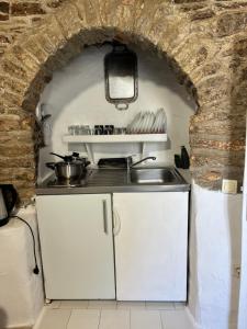 a kitchen with a sink and a brick wall at The Windmill in Symi +16 photos