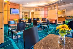 a restaurant with tables and chairs and a tv at SpringHill Suites Prince Frederick in Prince Frederick