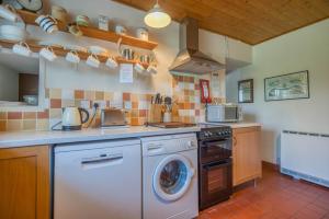 a kitchen with a washer and a dishwasher at Ty Canol in Goodwick +32 photos