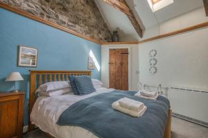 a bedroom with a large bed with towels on it at Ty Canol in Goodwick