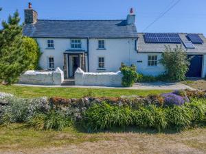 a white house with solar panels on the roof at Ty Canol in Goodwick