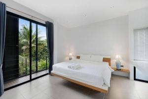 a bedroom with a white bed and a large window at Anas house in Lipa Noi in Lipa Noi