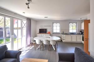 a kitchen and living room with a table and chairs at Haus Strandbrise Graal-Müritz in Graal-Müritz