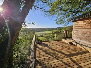 a wooden deck with a view of a field at Cosy Treehouse in Pontypool