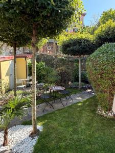 a garden with a table and chairs and trees at Miracolo di Mare Retro in Piran