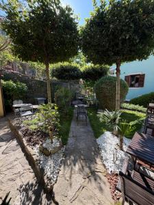 a garden with tables and chairs and trees at Miracolo di Mare Retro in Piran