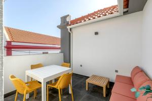 a balcony with a table and chairs and a couch at Casablanca 2BR Horizon in Caparica