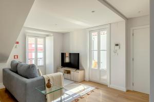 a living room with a couch and a television at Casablanca 2BR Horizon in Caparica