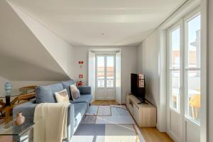 a living room with a blue couch and a tv at Casablanca 2BR Horizon in Caparica