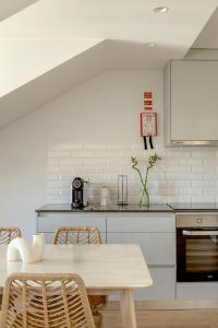a white kitchen with a table and chairs at Tulum Bohemian 2BR Apartment in Caparica