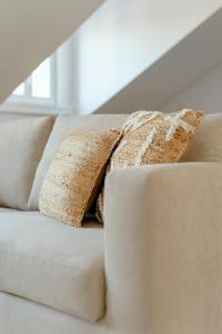 a white couch with two pillows on it at Tulum Bohemian 2BR Apartment in Caparica
