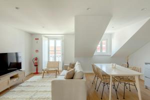 a living room with a couch and a table at Tulum Bohemian 2BR Apartment in Caparica +26 photos