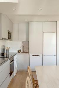 a kitchen with white cabinets and a white table at Tulum Bohemian 2BR Apartment in Caparica