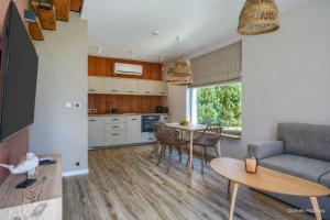 a kitchen and living room with a table and a couch at Jesionowa 3 Domki in Rowy