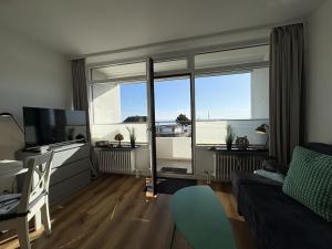 a living room with a couch and a large window at Strandhotel - 19 "Sardinenbüchse" in Dahme