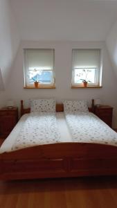 a bedroom with two windows and a bed with white sheets at Apartment Rozika in Slovenj Gradec +39 photos