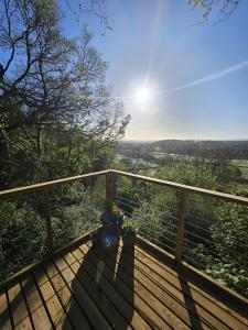 a wooden deck with a view of the countryside at Cosy Treehouse in Pontypool