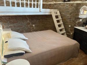 a bedroom with a bunk bed with pillows and a ladder at The Windmill in Symi