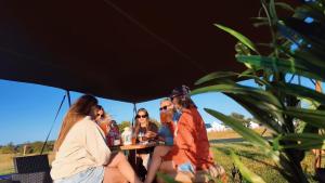 a group of people sitting at a table under an umbrella at The Old Airfield Campsite in Bransgore