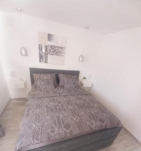 a bedroom with a bed with a brown comforter at Apartmani Lea in Bribir