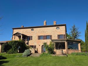 a large brick house on a green lawn at Città della Pieve Retreat in Città della Pieve