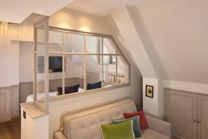 a living room with a couch and a window at Charles V in Paris
