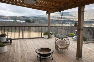 a wooden deck with a table and chairs on it at Cherry trees & mount Hermon views,near ram pool in Majdal Shams