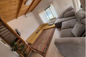 an overhead view of a living room with a couch and stairs at Cherry trees & mount Hermon views,near ram pool in Majdal Shams
