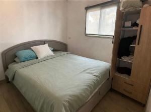 a small bedroom with a bed and a window at Cherry trees & mount Hermon views,near ram pool in Majdal Shams