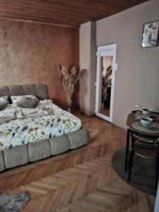a bedroom with a bed and a table in it at NeNa Apartmani - Ruma #2 in Ruma +2 photos