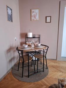a dining room table with chairs and a small table with a table at NeNa Apartmani - Ruma #2 in Ruma