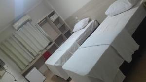 a hospital room with two beds and a shower at Flat 55 Goiania in Goiânia