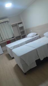 two beds in a hotel room with at Flat 55 Goiania in Goiânia
