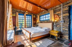 a bedroom with a bed in a stone wall at The Boho Mukteshwar in Mukteshwar