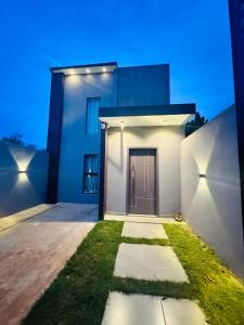 a white house with a door and grass at Casa independiente en Ciudad del Este in Ciudad del Este