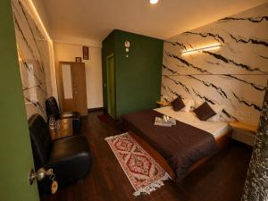 a hotel room with a bed and a chair at Peakaboo Manali in Manāli