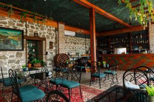 a patio with chairs and tables and a bar at Golden Pheasant in Tbilisi City