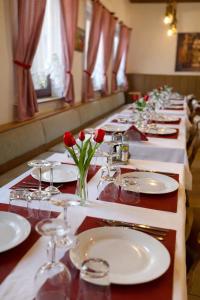 a long table with white plates and red roses on it at ESER Hotel Apartment in Hertingen