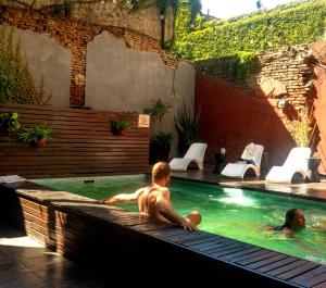 a man sitting in a swimming pool at Circus Hostel in Buenos Aires