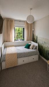 a bedroom with a large bed with a window at Private room in shared house at Casa de Charlie in Lambeg